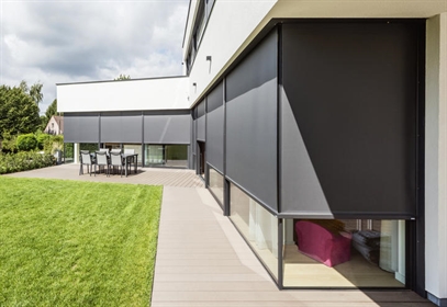 A private residence with black coloured motorized external window screens 