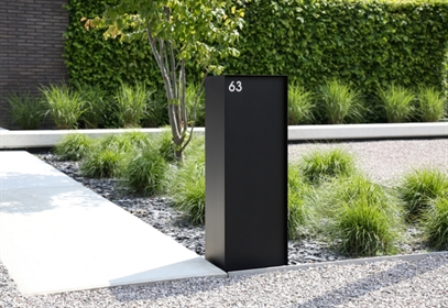black mailbox with integrated numbers in silver in a garden