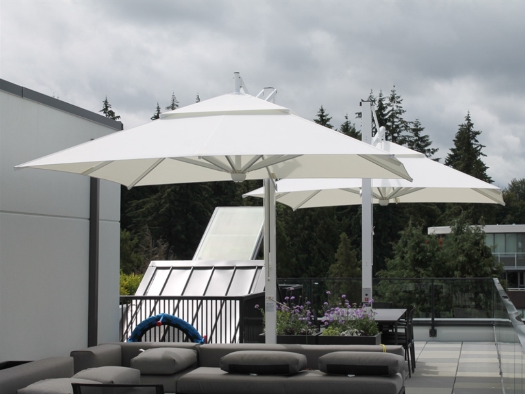 Two white umbrellas shade a rooftop patio