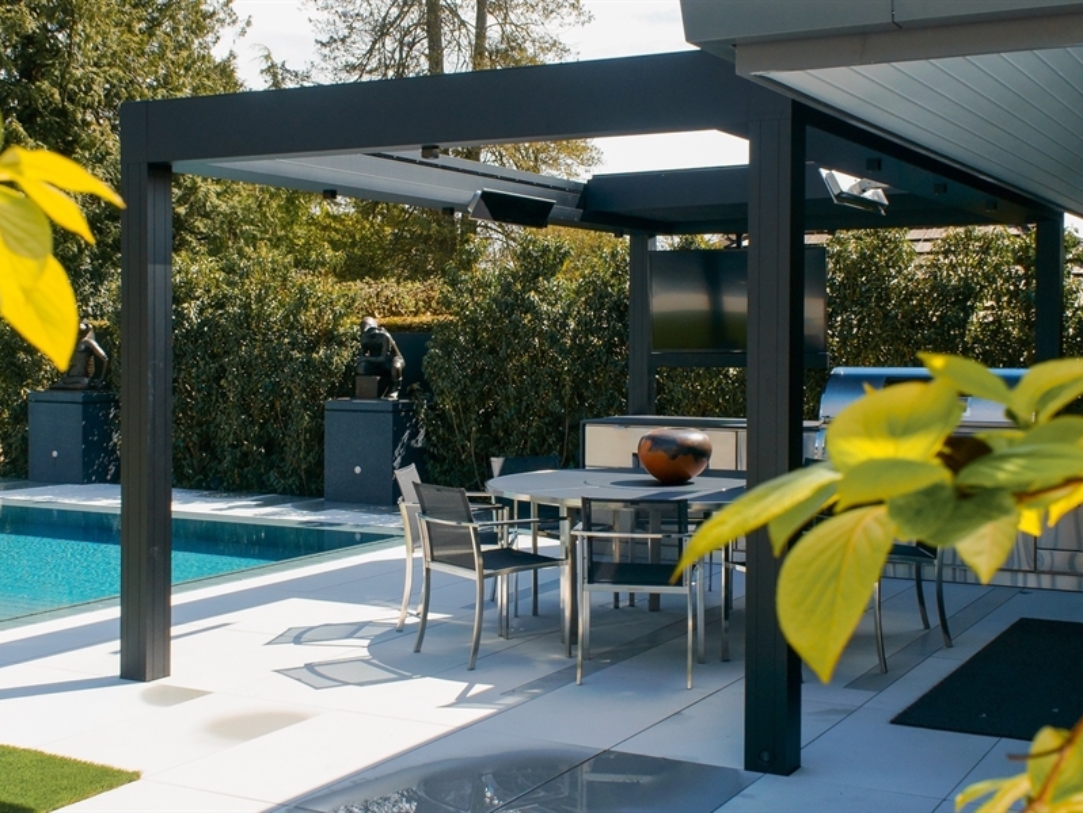 A pergola shades a backyard patio on a sunny day A pergola shades a backyard patio on a sunny day