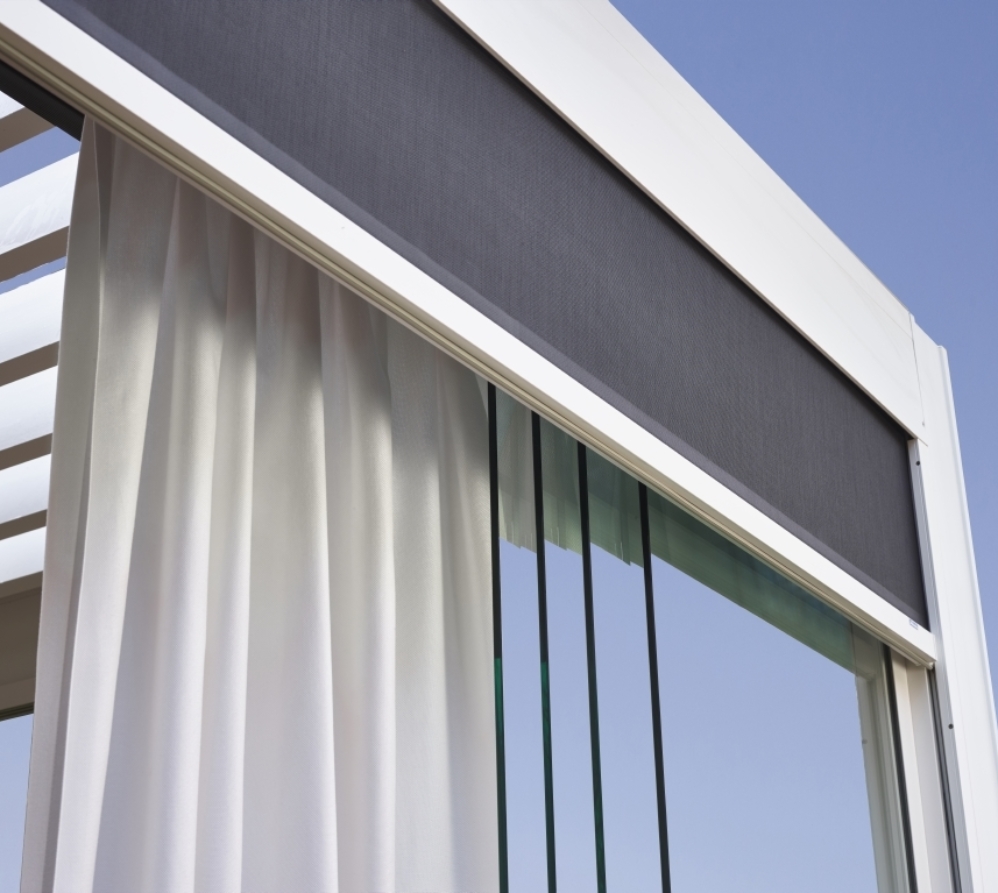 grey mesh curtains installed inside the frame of a bioclimatic pergola system for privacy