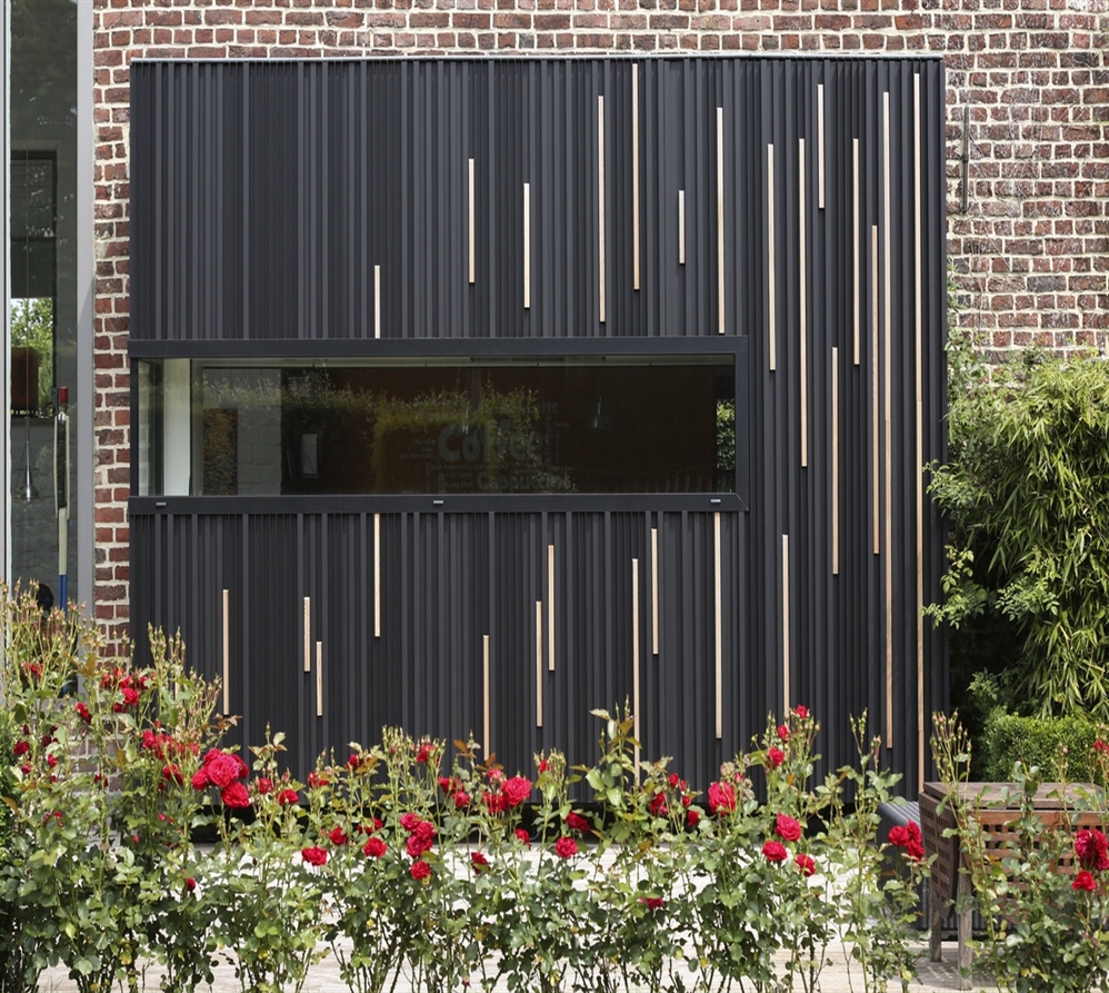 black strip facade cladding installed against a building with wooden strips integrated