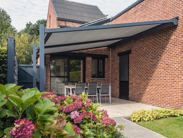 Renson Lapure retractable awning attached to a home with a brick style wall