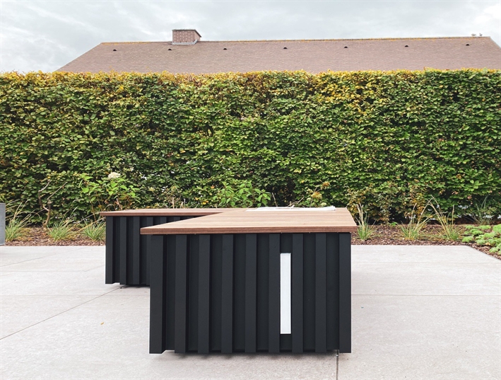 black outdoor seating unit with an led lighting strip on a concrete patio