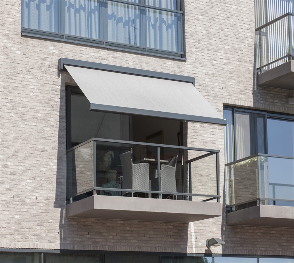 Compact terrace with a sleek fabric awning mounted above sliding glass doors.