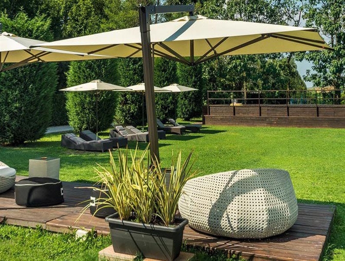yellow outdoor umbrellas placed in different placed in a backyard setting with seating underneath